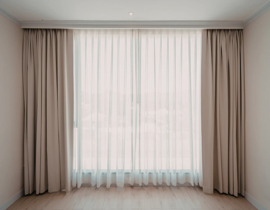 Floor-to-ceiling sheer curtains with neutral drapery panels